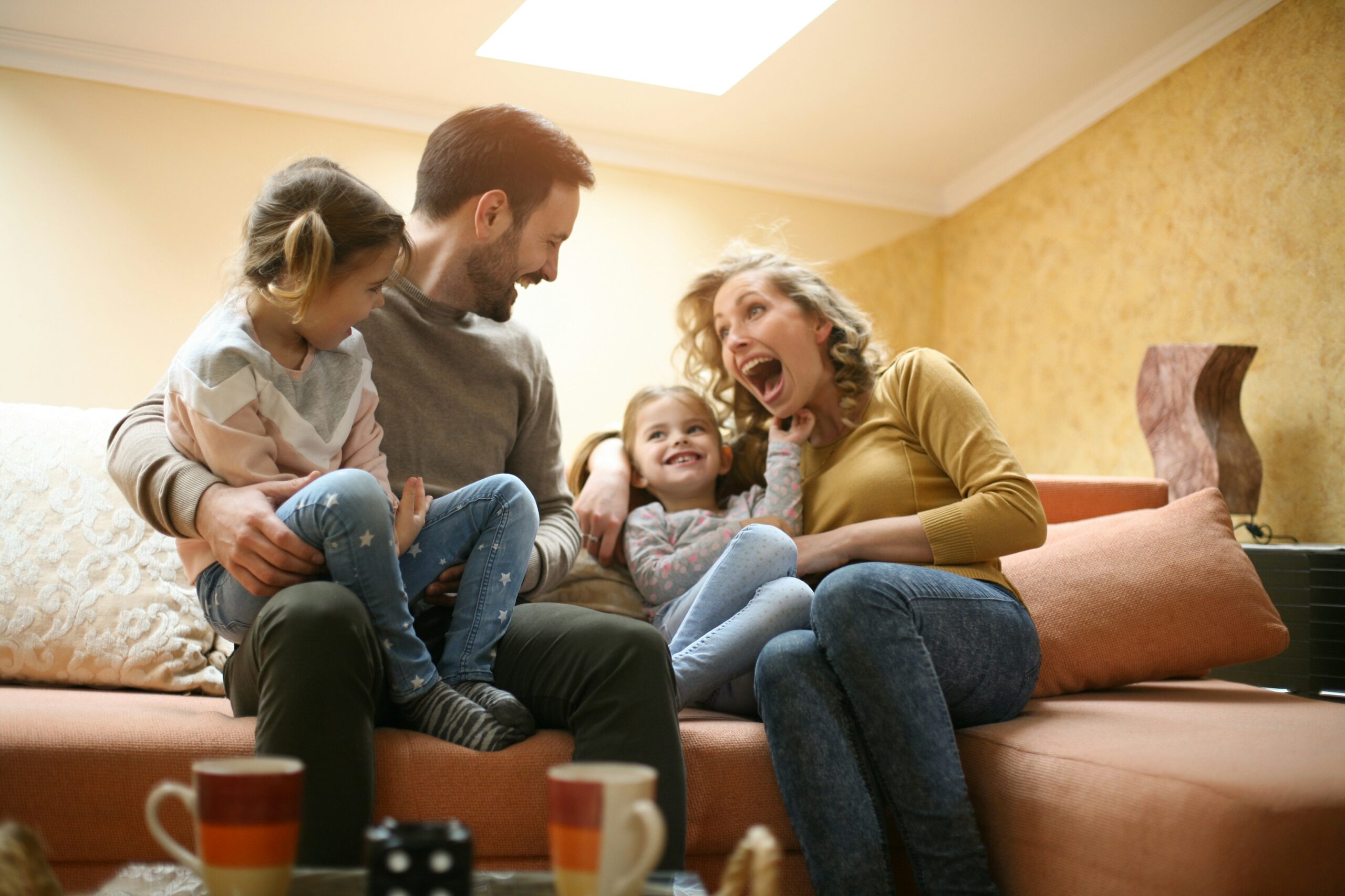 A family laughing together on a couch.
